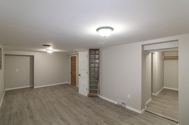 finished below grade area featuring visible vents, baseboards, and wood finished floors