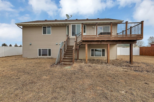 rear view of property with stairway, a wooden deck, and fence