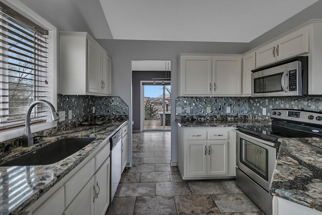 kitchen with a sink, decorative backsplash, appliances with stainless steel finishes, and white cabinets