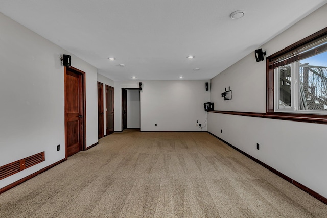 unfurnished room featuring recessed lighting, light colored carpet, and baseboards