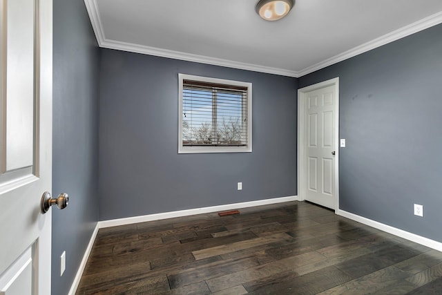 spare room with dark wood-style flooring, baseboards, and ornamental molding