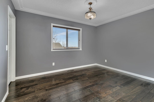 empty room featuring visible vents, baseboards, dark wood-style flooring, and a textured ceiling