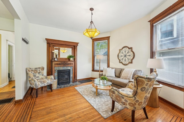 living room with baseboards, hardwood / wood-style flooring, and a fireplace