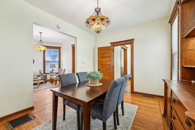 dining area featuring light wood-style flooring and baseboards