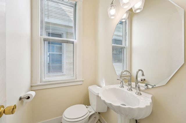 bathroom featuring a sink, toilet, and baseboards