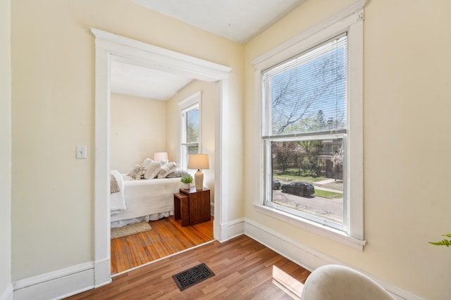 living area with wood finished floors, plenty of natural light, and baseboards