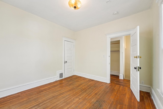 unfurnished bedroom featuring hardwood / wood-style floors and baseboards