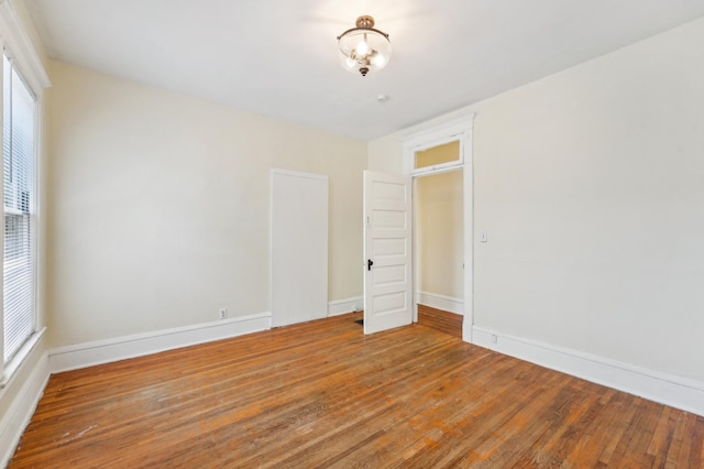 spare room featuring wood finished floors and baseboards