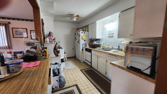 kitchen with wallpapered walls, ceiling fan, light floors, and a textured ceiling