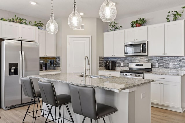 kitchen featuring a sink, light wood-style floors, white cabinetry, and stainless steel appliances