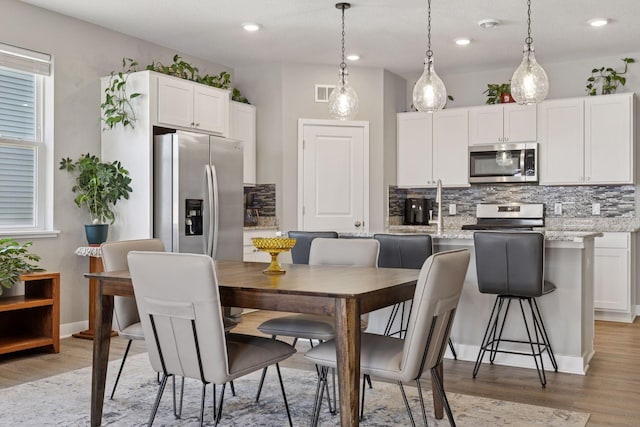 kitchen featuring visible vents, tasteful backsplash, appliances with stainless steel finishes, and white cabinetry