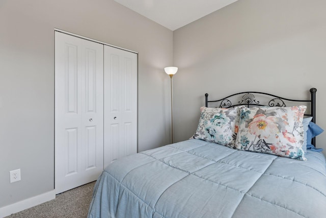 carpeted bedroom with baseboards and a closet