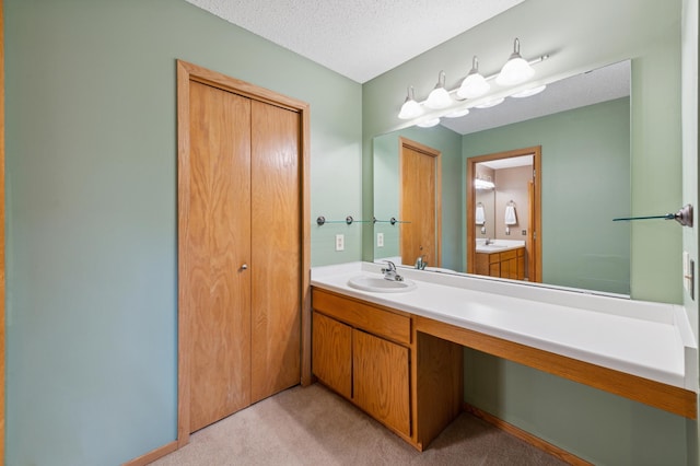bathroom with vanity, baseboards, and a textured ceiling