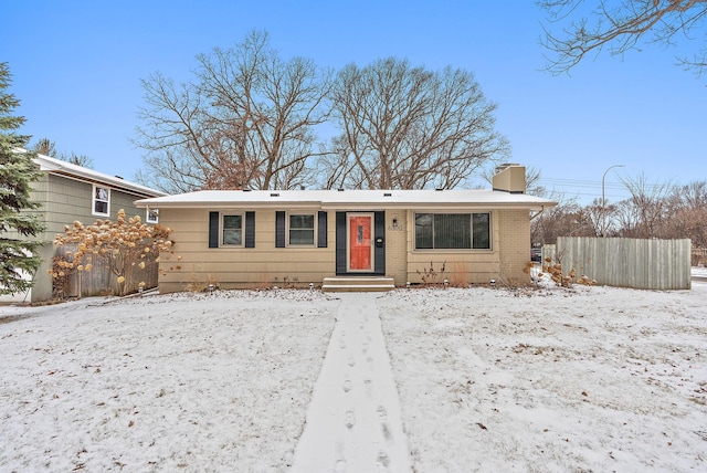 single story home with brick siding, a chimney, and fence