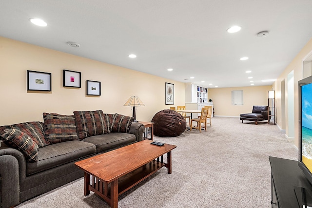 living room with recessed lighting, baseboards, and light colored carpet