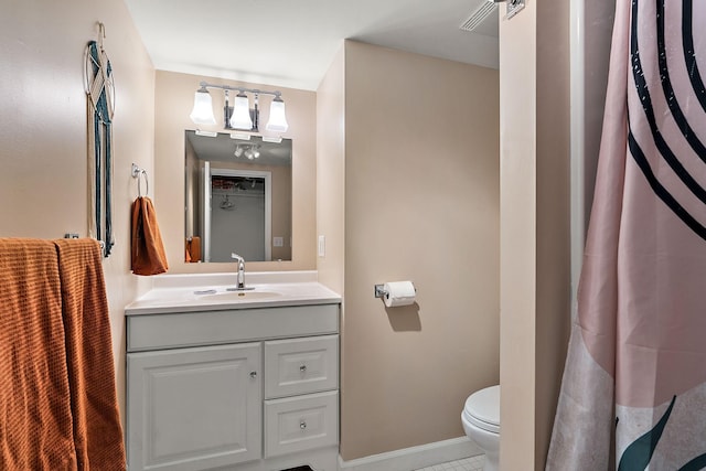 bathroom featuring toilet, vanity, and baseboards