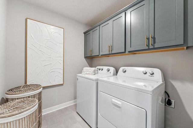 washroom with baseboards, cabinet space, and independent washer and dryer