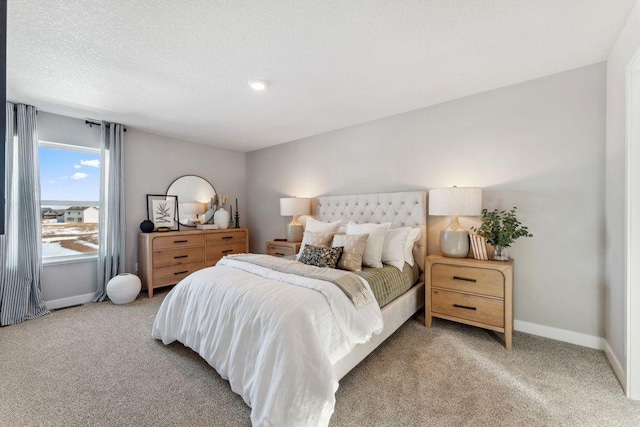bedroom with a textured ceiling, baseboards, and light carpet