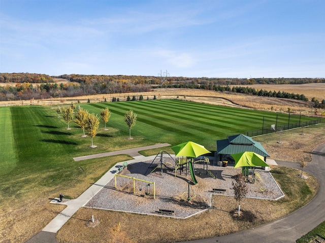 view of community featuring a rural view, a lawn, and playground community