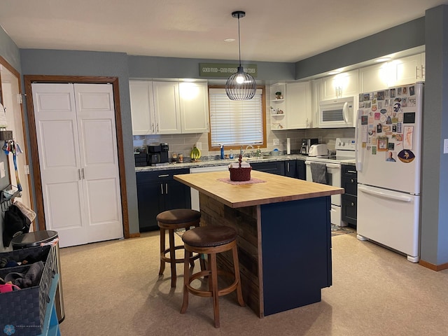 kitchen featuring butcher block countertops, a kitchen breakfast bar, a center island, white appliances, and white cabinets