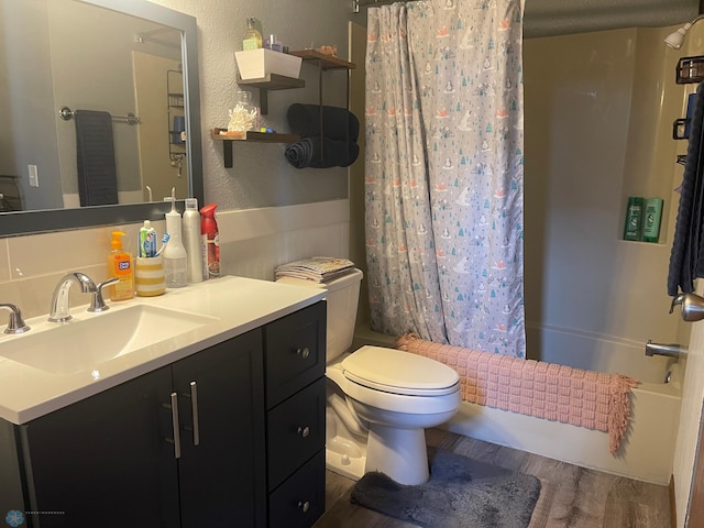 full bath with vanity, wood finished floors, toilet, a textured wall, and shower / tub combo with curtain