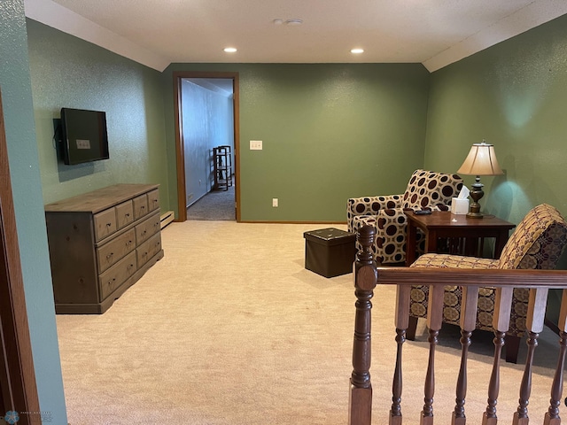 sitting room with light carpet, recessed lighting, and a textured wall