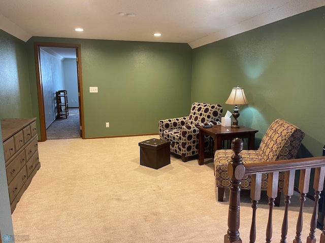 living area with recessed lighting, light colored carpet, baseboards, and a textured wall