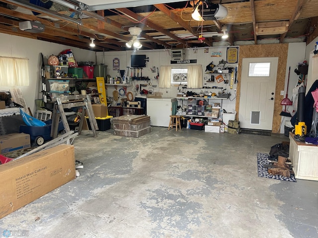 garage featuring a ceiling fan, a workshop area, and a garage door opener