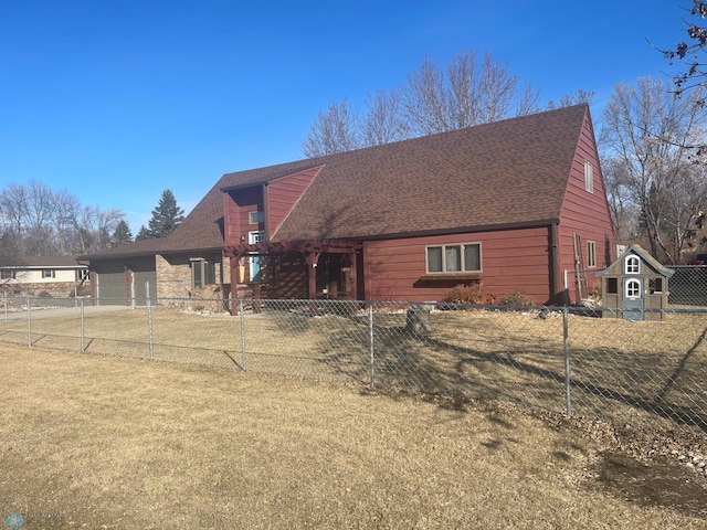 view of front of home with fence private yard, an attached garage, a shingled roof, and a front lawn