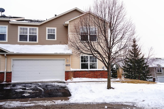 view of property featuring brick siding and a garage