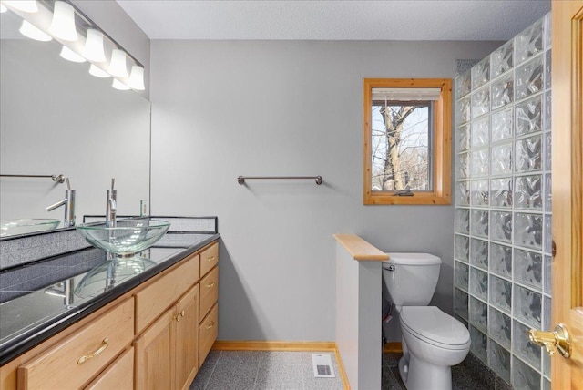 bathroom featuring visible vents, baseboards, toilet, and vanity