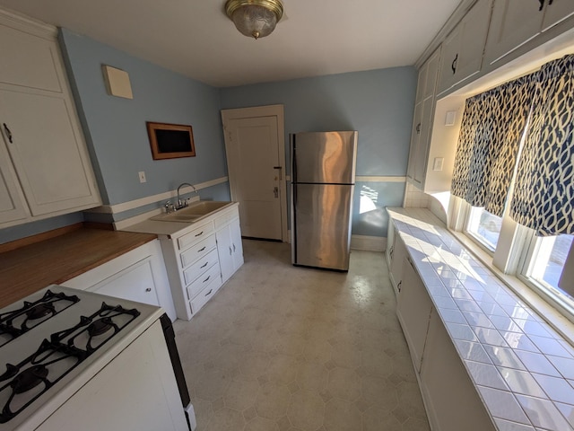 2309 Buchanan St NE, Minneapolis, MN 55418 - kitchen with a sink, white range with gas stovetop, light floors, and freestanding refrigerator