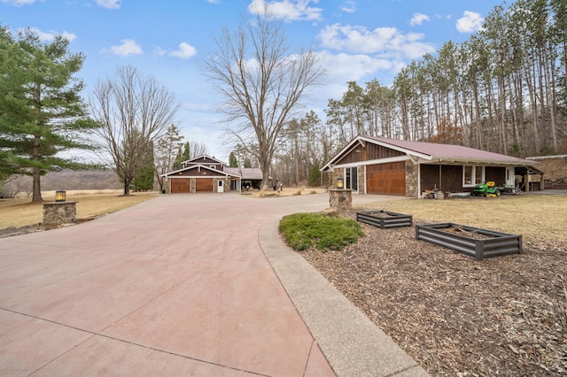 N2699 County Road A, Salem Twp, WI 54750 - exterior space with concrete driveway, stone siding, and an attached garage