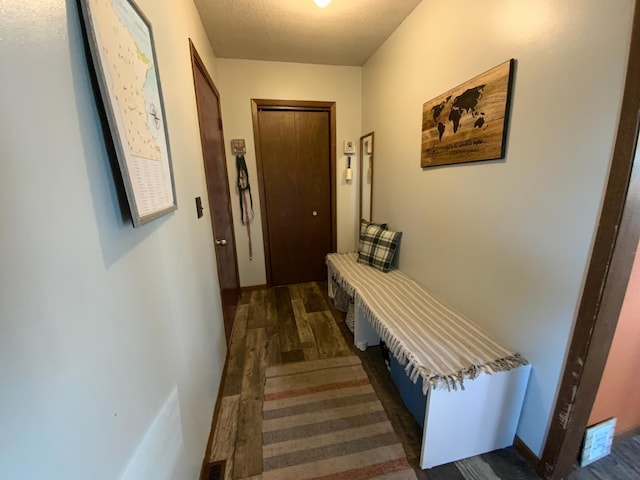 hall featuring wood finished floors and a textured ceiling