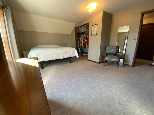 bedroom with a closet, baseboards, carpet, and vaulted ceiling