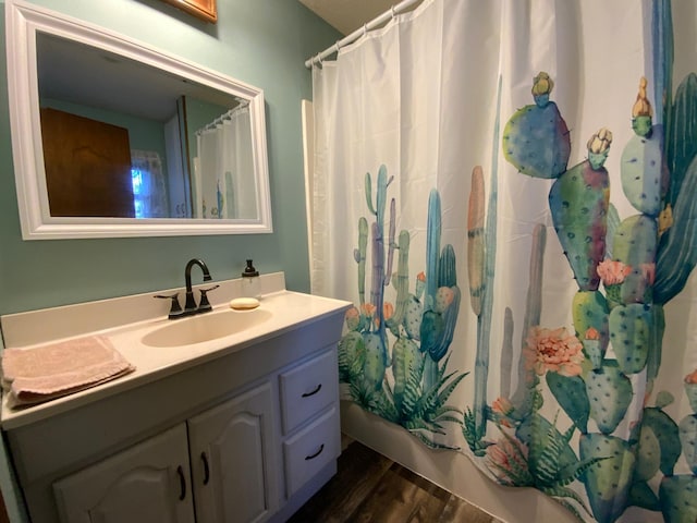 full bath with vanity, shower / tub combo with curtain, and wood finished floors