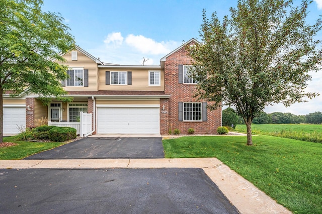 view of front of home featuring a front lawn, an attached garage, brick siding, and driveway