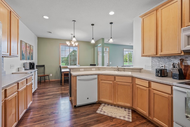 kitchen featuring light brown cabinets, a notable chandelier, white appliances, and a sink