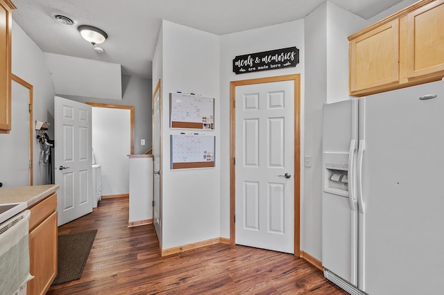 kitchen featuring visible vents, white fridge with ice dispenser, dark wood-style floors, and light brown cabinetry