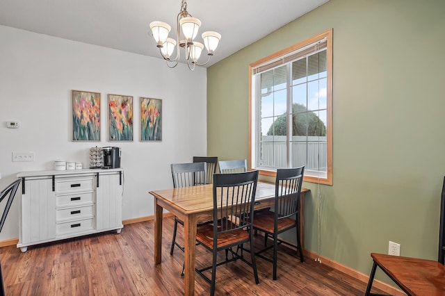 dining area with baseboards, an inviting chandelier, and wood finished floors