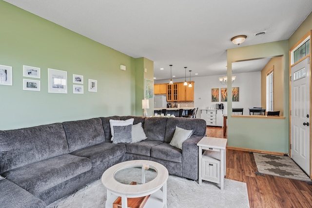 living area with visible vents, baseboards, light wood-type flooring, recessed lighting, and a notable chandelier