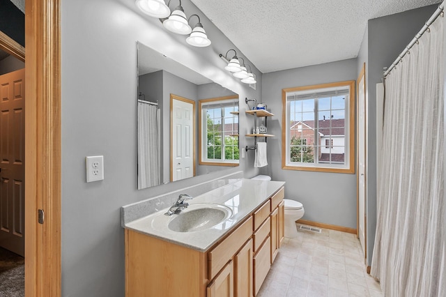 bathroom with visible vents, toilet, a textured ceiling, baseboards, and vanity