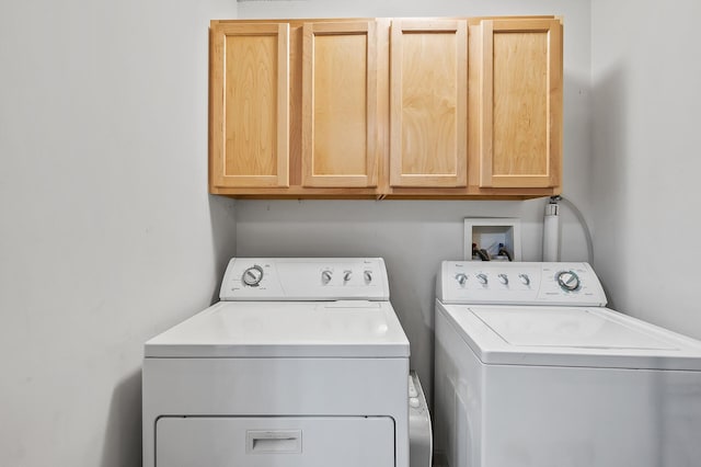 laundry area featuring washing machine and clothes dryer and cabinet space