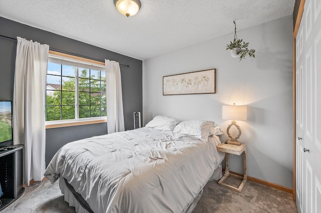 bedroom featuring carpet flooring, baseboards, a closet, and a textured ceiling