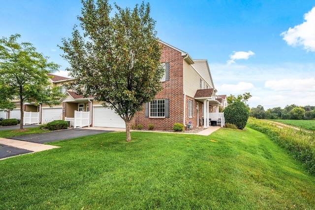 view of front of property with aphalt driveway, a garage, brick siding, and a front lawn