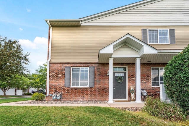 exterior space with a lawn and brick siding