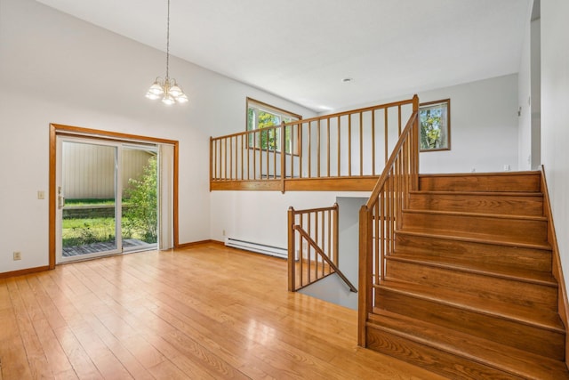 2605 Forest St, Maplewood, MN 55109 - unfurnished living room with a chandelier, baseboard heating, baseboards, and hardwood / wood-style floors