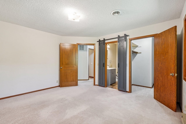 2605 Forest St, Maplewood, MN 55109 - unfurnished bedroom with light carpet, a spacious closet, a textured ceiling, a closet, and baseboards
