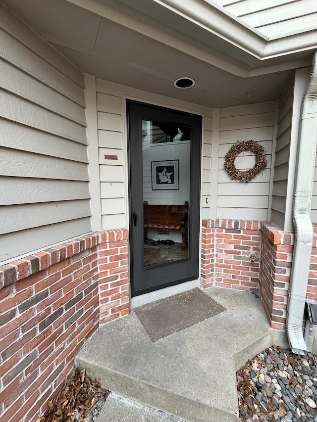 view of exterior entry featuring brick siding