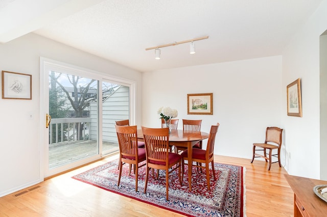 dining room with track lighting, visible vents, and light wood finished floors